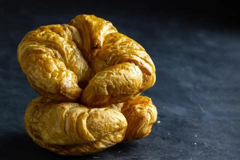 Croissant on table in dark background. Stock Photos