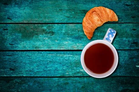 Croissant with the tea on table Stock Photos