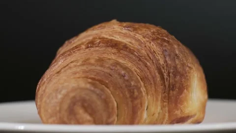 Croissant on white plate rotating in front of camera, Close-up Stock-Footage 167524987