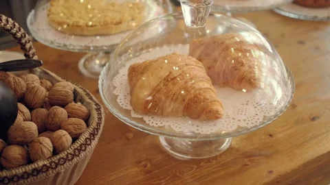 Croissants displayed in bakery with fresh nuts on table Stock Footage 335612956