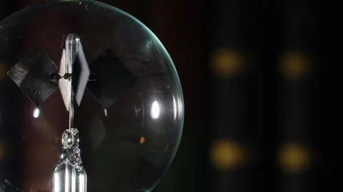 Crookes Radiometer Light Mill with Gold Reflections on Bookshelf, Left Align Stock Footage 331100856