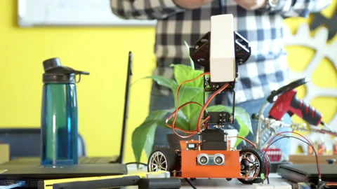 Crop anonymous man controlling robot in class Stock Footage 140765377