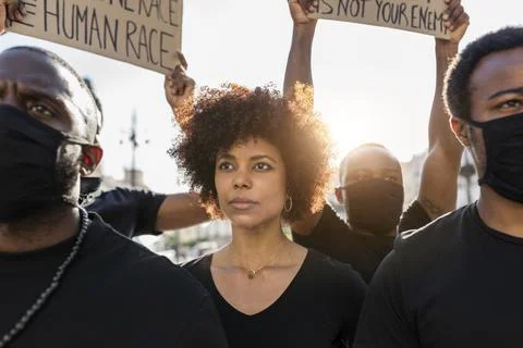 Crop black protesters with placards on strike in town Stock Photos