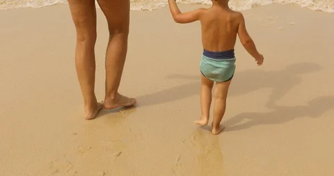 Crop boy with parent walking on beach Stock Footage 100131971