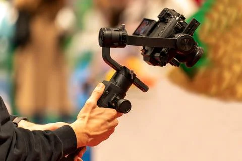 Crop cameraman with camera on stabilizer Stock Photos