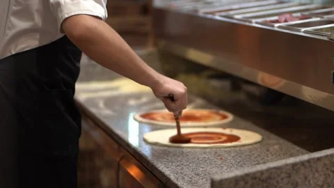 Crop chef adding tomato sauce on pizza dough in kitchen Stock Footage 238814026
