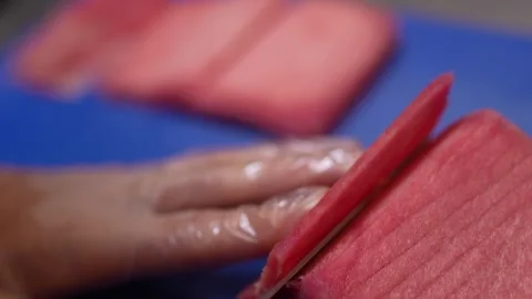 Crop chef cutting slices of red tuna with knife Stock Footage 250597214