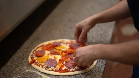 Crop chef decorating pepperoni pizza with pepper Stock Footage 238813717
