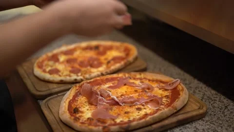 Crop chef dropping prosciutto slices into pizza Stock Footage 238813821