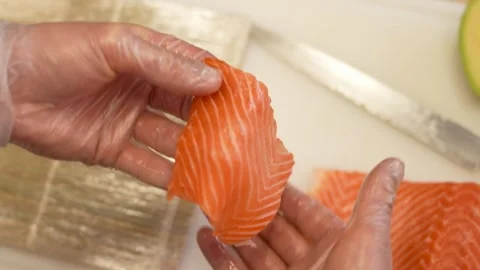 Crop chef making salmon sushi rolls in restaurant kitchen Stock Footage 249075194