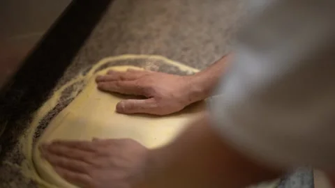 Crop chef spreading dough for making pizza in restaurant kitchen Stock Footage 239526913