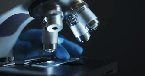 Crop closeup shot of microscope in the laboratory, scientist is conducting study Vídeos de archivo 125770945