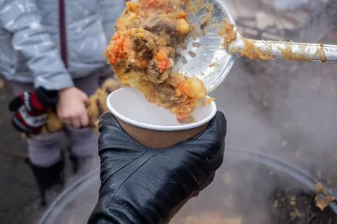Crop cook serving stew to client Stock Photos