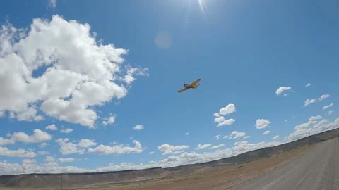 Crop Dusting Bush Plane Flying Low Over Dirt Road in the Desert Stock Footage 220043646