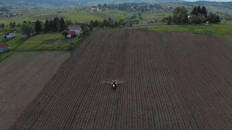 Crop dusting with tractor on field Stock Footage 90400538
