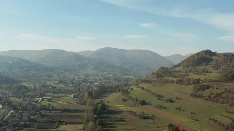 Crop fields below forested mountains from above 库存影片 145489375
