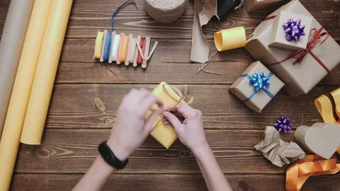 Crop hands decorating wrapped box with string Stock Footage 69929570