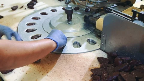 Crop hands putting sweets into wrapping machine. Candy factory. Video stock 98011456