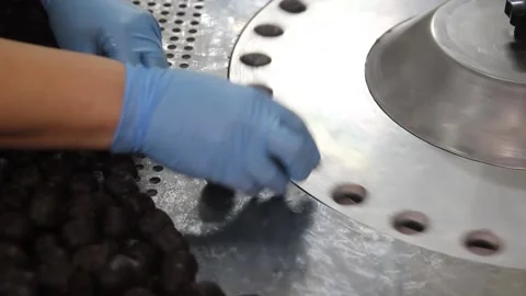 Crop hands putting sweets into wrapping machine. Hands of unrecognizable female Stock Footage 148349110