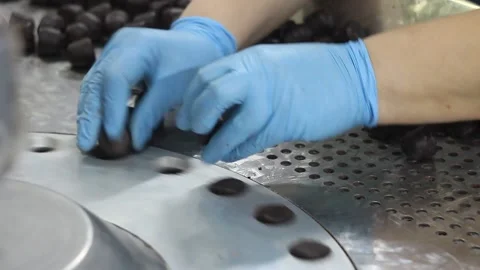 Crop hands putting sweets into wrapping machine. Hands of unrecognizable female Stock Footage 148349158