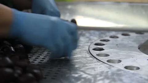 Crop hands putting sweets into wrapping machine. Hands of unrecognizable female Stock Footage 148349196