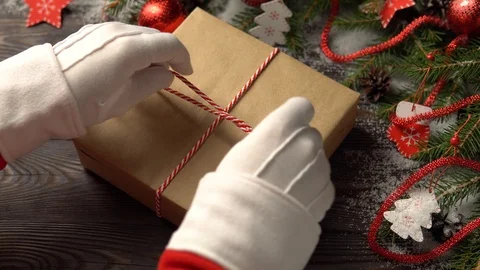 Crop hands of Santa tying gift near conifer branches Stock Footage 101604576