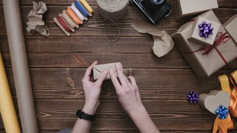 Crop hands sealing gift box with paper Stock Footage 69928020
