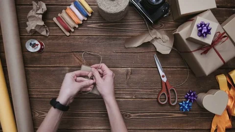 Crop hands wrapping present with string Stock Footage 69928741