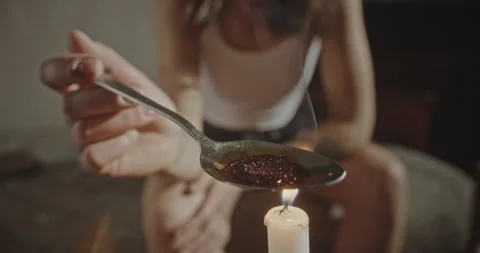 Crop junkie preparing dose of heroin. Soft focus of anonymous woman boiling dose Stock Footage 173332453