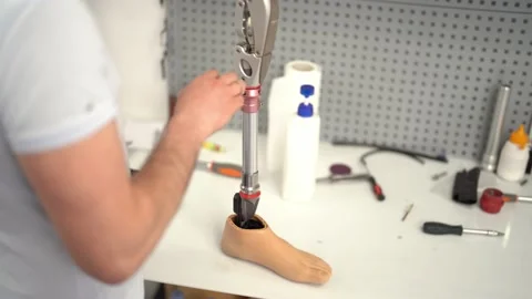 Crop man assembling prosthetic foot with screwdriver Stock Footage 236621758