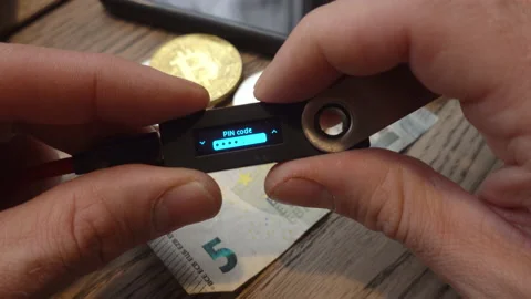 Crop man entering pin code on hardware wallet Stock Footage 152759917