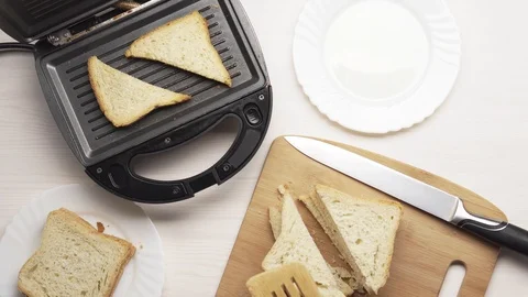 Crop man making toasts in electric grill 库存影片 104056706