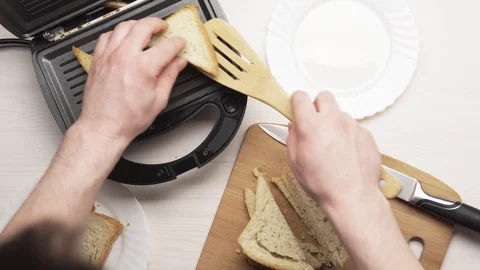 Crop man making toasts in electric grill Stock Footage 104058138