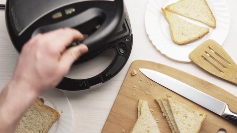 Crop man making toasts in electric grill Stock Footage 104059319