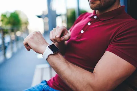 Crop man using smart watch while sitting outside Stock Photos