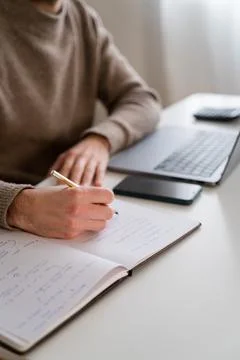 Crop man writing in notepad while working on project Stock Photos