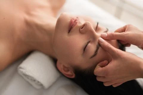 Crop masseuse doing massage to client Stock Photos