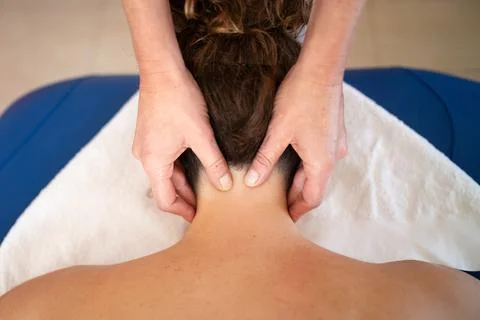 Crop masseuse massaging trigger points on neck of woman Stock Photos