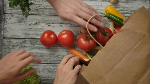 Crop people taking groceries out from paper bag Stock Footage