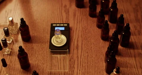 Crop perfumer adding oil into bottle on electronic scales Video stock 260985627