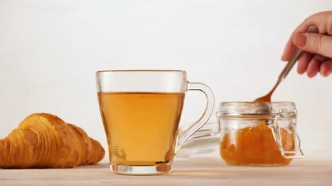 Crop person adding jam into tea Stock Footage 136673675
