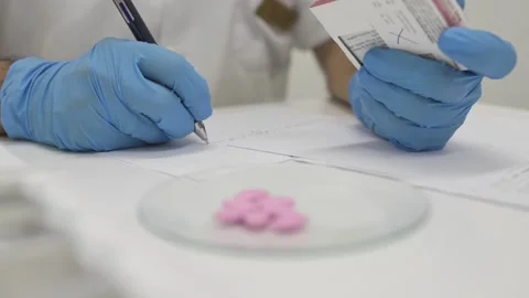 Crop pharmacist taking notes while working with drugs in lab Stock Footage 269342101