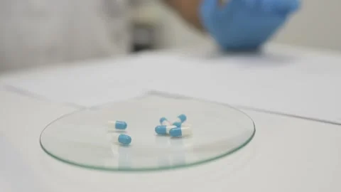 Crop pharmacist working with documents while making personalized pills Stock Footage 269340561