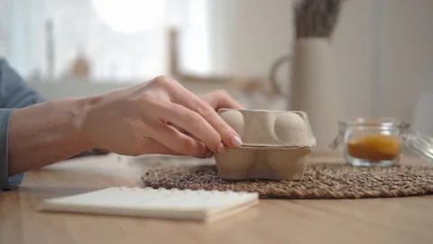 Crop shot: taking out an egg from cardboard, inspects it for cooking Video stock 125093466