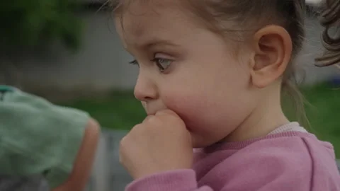 Crop side view of a cute little girl in casual clothes eating cherries outside Stock Footage 244812223