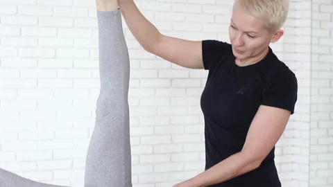 Crop tutor supporting woman doing asana 스톡 동영상 85483484