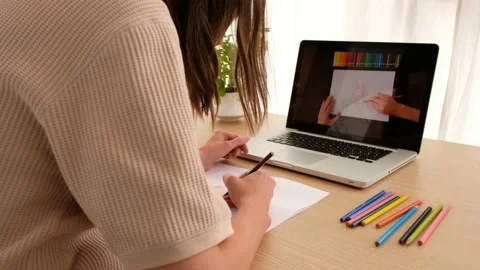Crop unrecognizable illustrator drawing using laptop with video tutorial Stock Footage 134017485