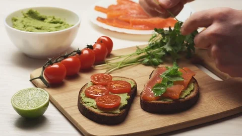 Crop view of chef decorating parsley leaves with avocado sandwiches. Stock Footage 104721083