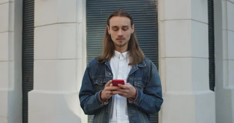 Crop view of long haired guy raising head and looking to camera while using his Stock Footage 138039505