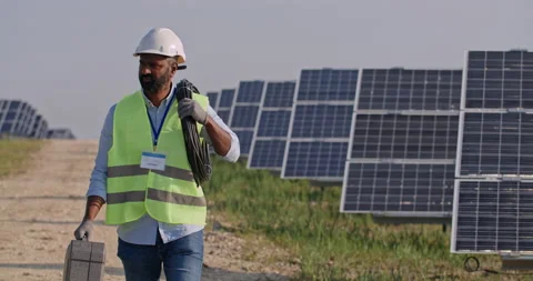 Crop view of male bearded engineer carrying cabel and case . Mixed race man in Stock Footage 141536345